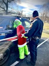 The Grinch being mock-arrested during the village’s tree lighting ceremony.