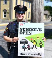 Village of Goshen Police Officer Jessica Racioppo with a AAA awareness poster.