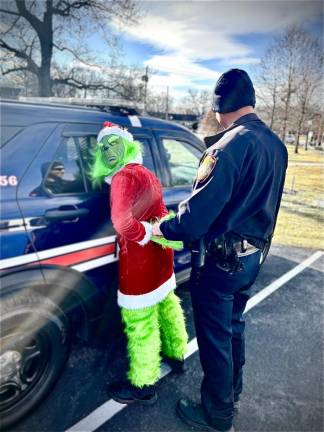 The Grinch being mock-arrested during the village’s tree lighting ceremony.