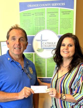 Goshen Rotary Club Vice President Mark Gargiulo presents a check for $1,000 to Catholic Charities of Orange, Sullivan, and Ulster Chief Advancement Officer Kristin Jensen.