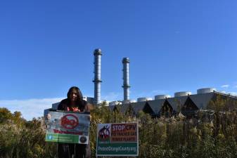 Pramilla Malick of Protect Orange County outside the CPV Valley Energy Center in Wawayanda, N.Y., across the street from a proposed warehouse, in October. ‘We’re on an irreversible trajectory if we don’t stop these projects.’