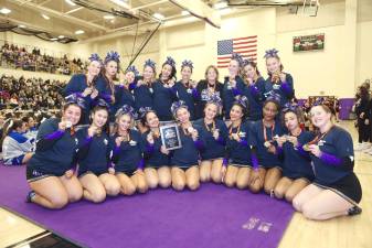 The Monroe-Woodbury Crusaders varsity cheerleading team celebrates their Section 9 Class A championship.