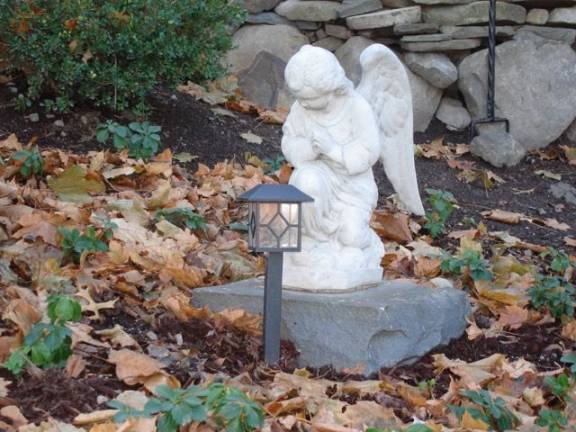 A prayful angelic statue in the medication garden behind the A.U.M.P. Church on Main Street in Goshen (Photo by Geri Corey)