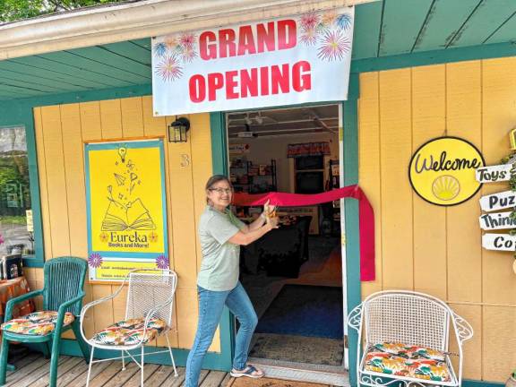 Elizabeth Barrett-Zahn cuts the ribbon on her now shop “Eureka Books and More.”