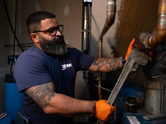 Ricardo Castillo disassembles the boiler at ADAPT of Hudson Valley’s residential location Nov. 22 in Westtown.