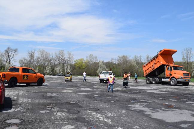 Photo by Erika Norton Workers from Orange County Paving could be seen working on the Goshen Plaza parking lot Friday.