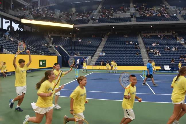 Players take a lap while Matchpoint President Ari Rogers finishes setting up pop-nets on Aug. 29.