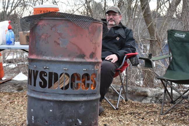 The burn barrel with NYSDOCCS (New York State Department of Corrections and Community Supervision) carved into it is symbolic, say the protesters, of their department going up in flames.