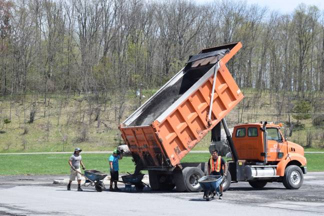 Photo by Erika Norton Workers from Orange County Paving could be seen working on the Goshen Plaza parking lot Friday.