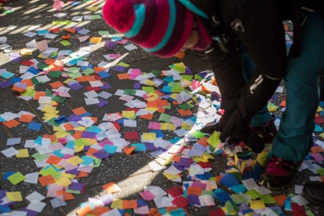 Children picked up fallen confetti from the ground