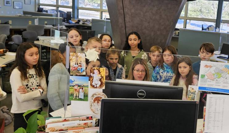 The students watch Straus News Director of Design Christina Scotti lay out the newspaper.